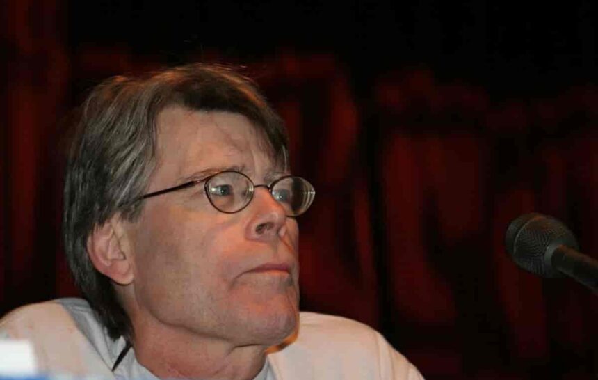 Stephen King we własnej osobie siedzący przed mikrofonem.